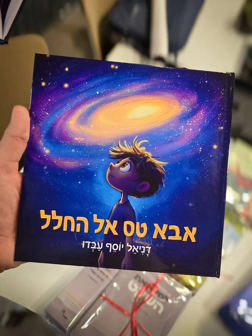 הספר המודפס בכריכה קשה, מוחזק ביד.